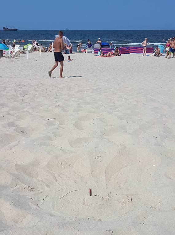 Turystka na play zrania si w nog nadepnwszy na wystajcy z piasku prt
